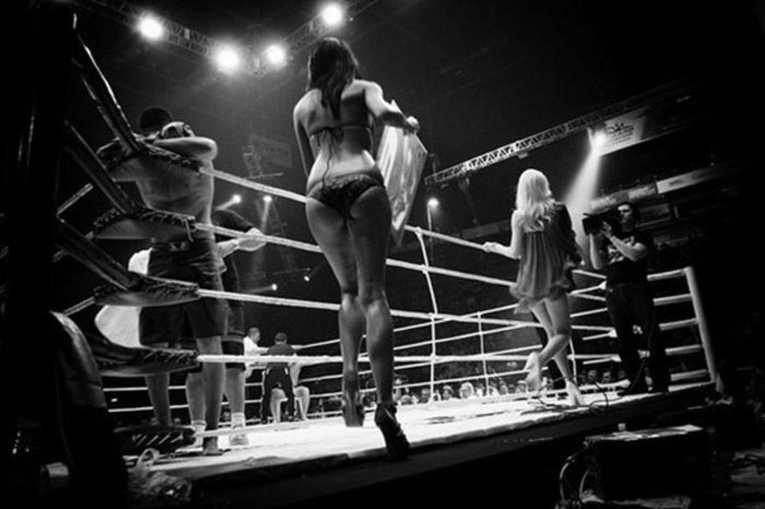 Черноволосая боксерша светит силиконовыми дойками на фоне ринга