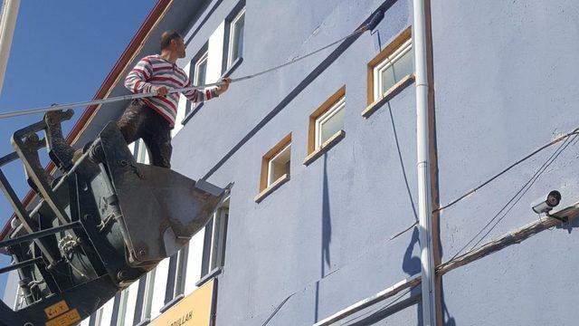 Okul müdürü, kepçenin kovasına binip okulu boyadı