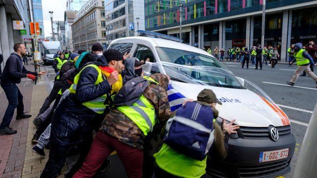 Göstericiler Brüksel'de polis minibüslerini ateşe verdi.