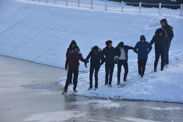 Öğrenciler el ele tutuşup, buz tutan gölet üzerinde yürümeye çalıştı