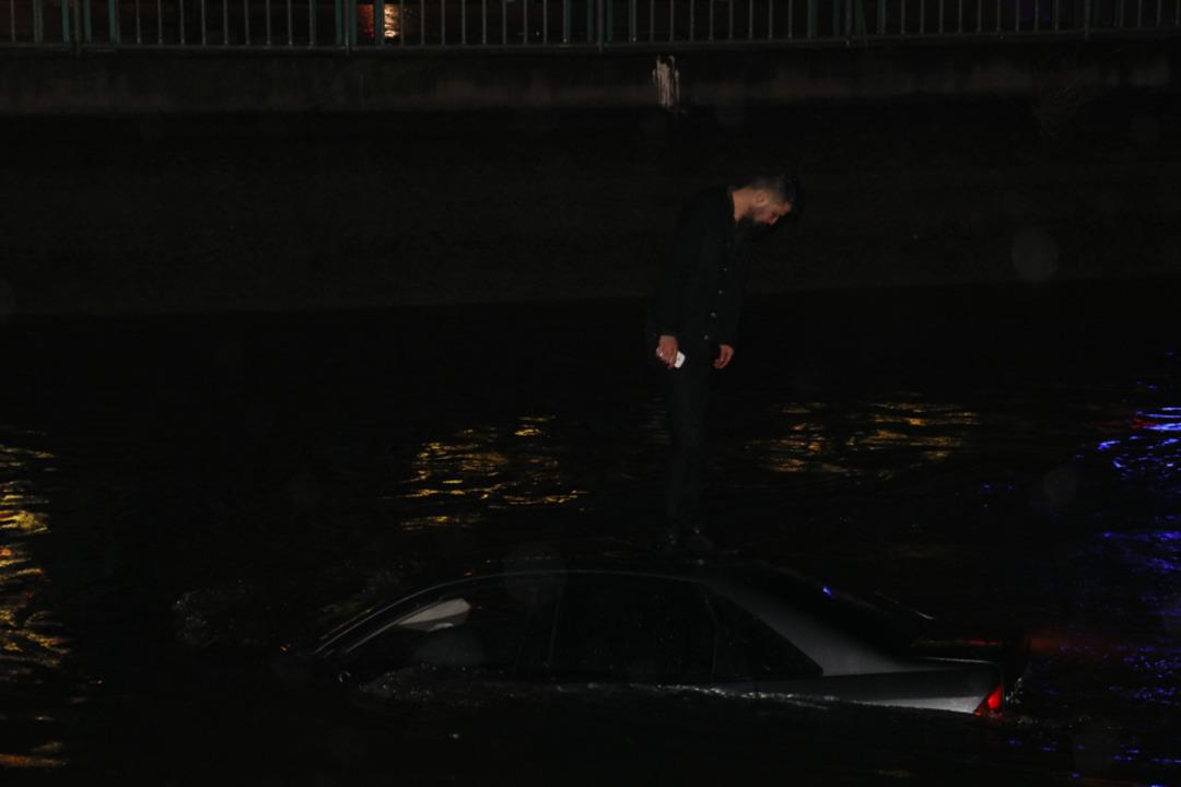 Kanala d&uuml;şen otomobilin &uuml;zerinde kurtarılmayı bekledi! Aracın s&uuml;r&uuml;c&uuml;s&uuml; ise bu sırada...