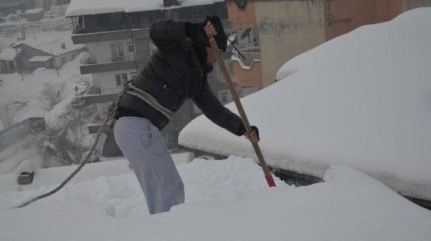 Hakkari'de yeni gelir kapısı: Günlük 100 TL'ye bellerine halat bağlayıp, çatıları kardan temizliyorlar