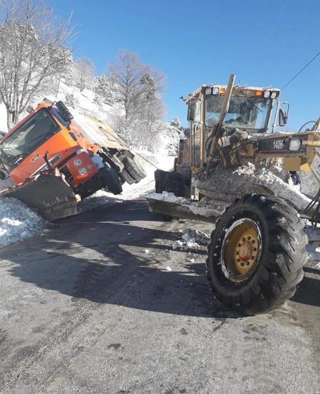 Karla kaplı yolda tuzlama çalışması yapan iş makinesi devrildi