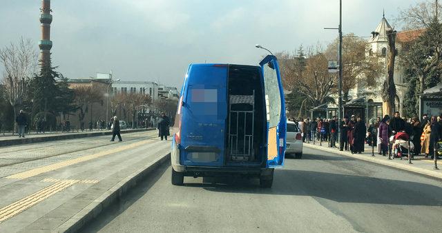 Kargo minibüsü, arka kapısı açık olarak trafikte seyretti