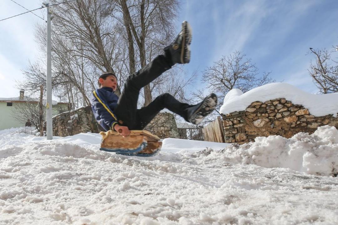 Mutlu olmalarına karlı bir tepe ile kızakları yetiyor 