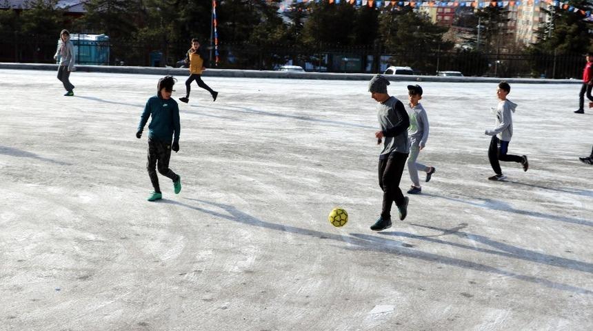 Öğrencilerin buzlu zeminde futbol keyfi