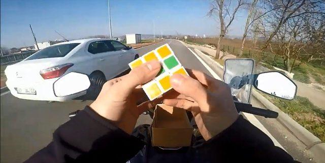 Motosiklet üzerinde rubik küp çözdü, oyun oynadı