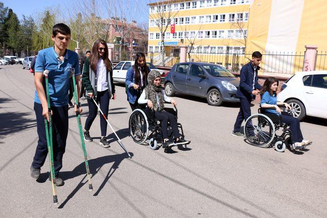 Liseliler farkındalık için tekerlekli sandalye ve bastonla gezdi