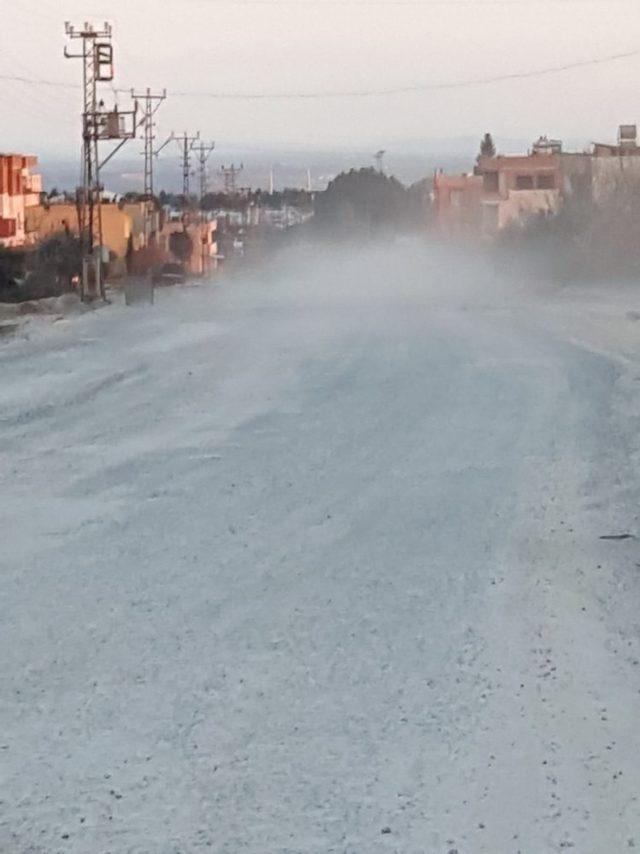 Yolda oluşan toza vatandaşlar su ile müdahale ediyor