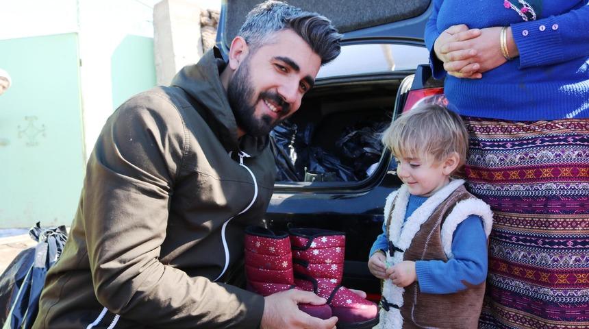 Fotoğraf &ccedil;ekerken başlattığı kampanyayla 20 bin &ccedil;ocuğa bot giydirdi