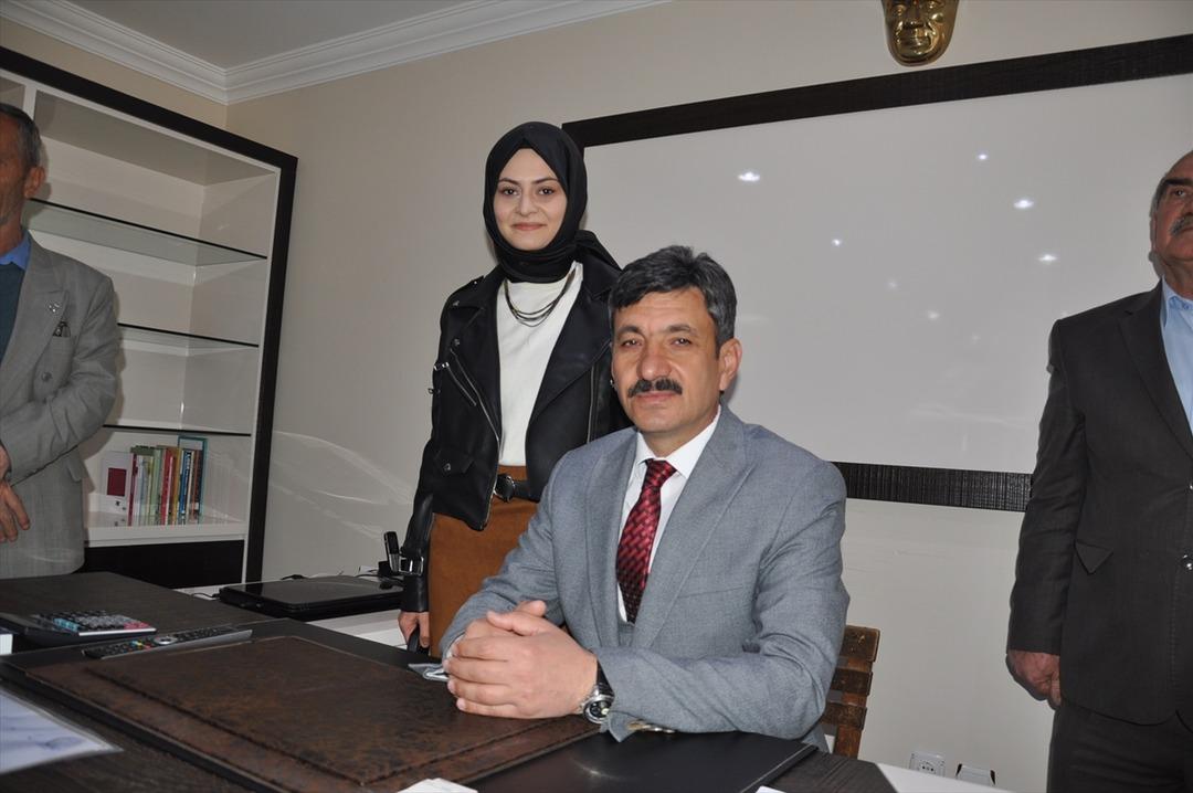 Makam koltuğunu kaldırıp tahta sandalyeye oturdu 