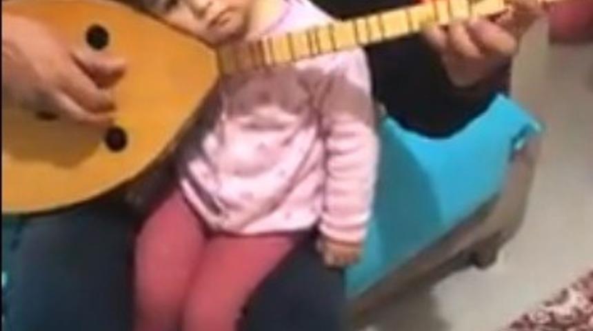 K&uuml;&ccedil;&uuml;k kızını bağlama ve t&uuml;rk&uuml;yle uyutuyor