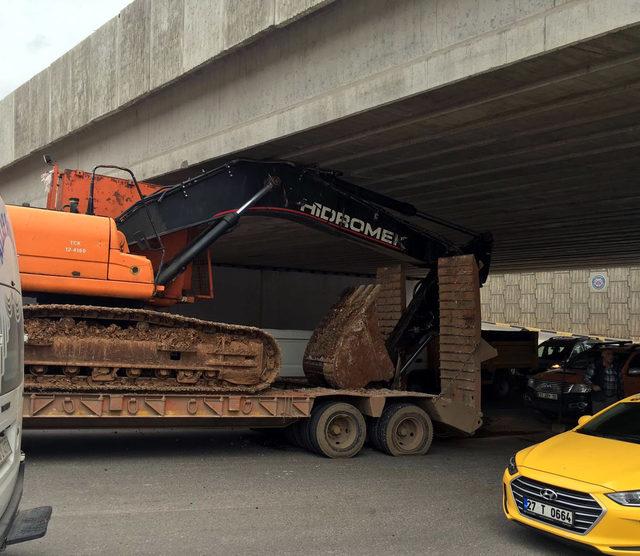 TIR, üstündeki iş makinesi ile köprüye takıldı