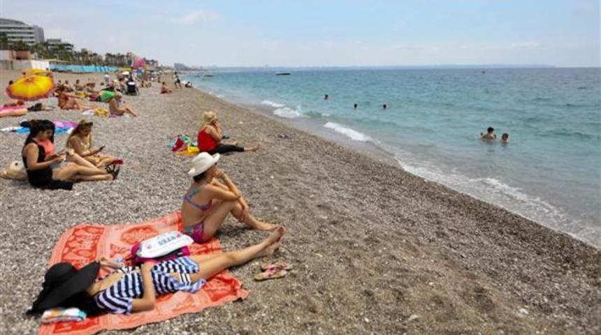 Antalya'da nemden bunalan Konyaaltı Sahili&rsquo;ne akın etti