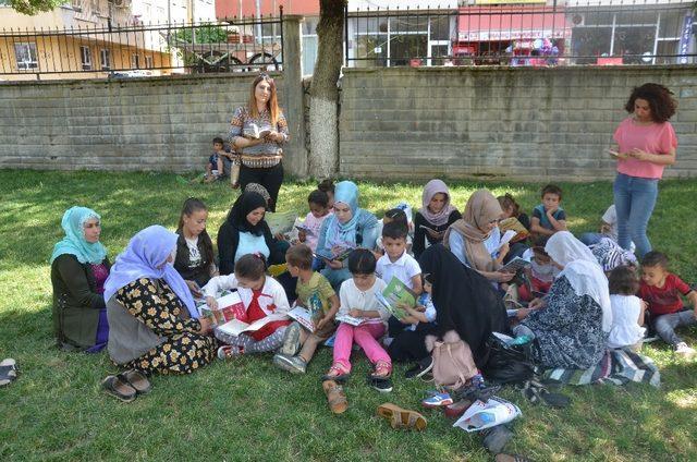 Kadınlar çocukları ile parkta kitap okudu