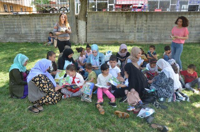 Kadınlar çocukları ile parkta kitap okudu