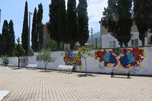 Kötü görünümlü duvarları çizimleriyle renklendiriyor