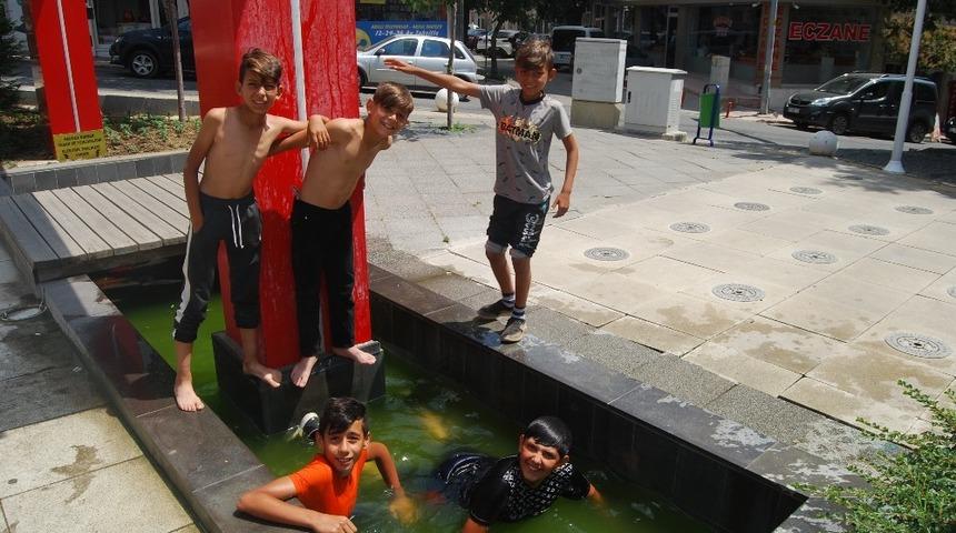 Sıcaktan bunalan çocuklar süs havuzunda serinledi