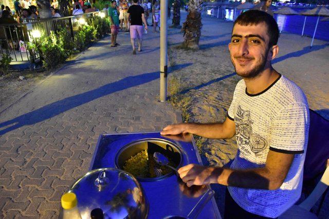 Niyazi, plajda bardakta mısır satarak ailesine destek oluyor