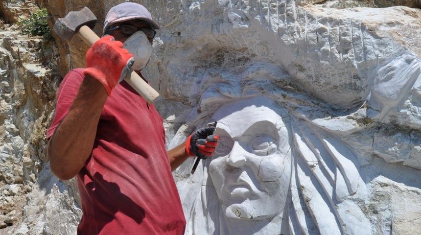 Kayalara kabartma resimler çiziyor