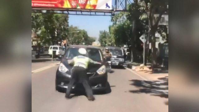 Trafik polisi, kırmızı ışıkta geçen otomobilin kaputuna çıktı