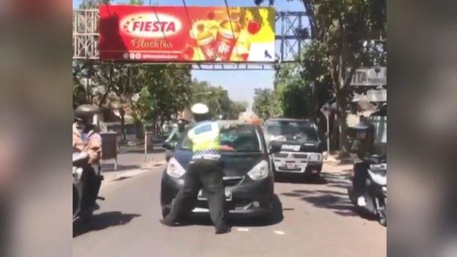 Trafik polisi, kırmızı ışıkta geçen otomobilin kaputuna çıktı