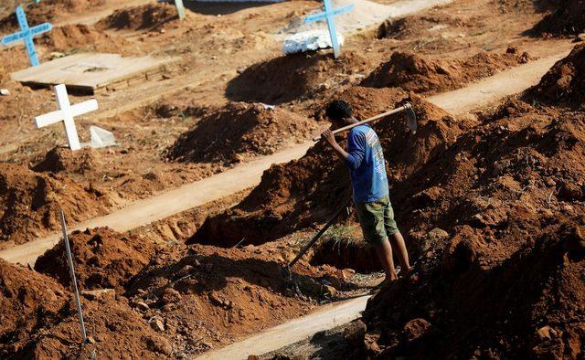 Brezilya'nın Altamira kentinde bir işçi, cezaevinde yaşamını yitirenler için kazılan mezarları hazırlarken. Altamira cezaevinde bir suç örgütünün başka bir çeteye saldırması sonucu tutuklu yaşamını yitirmişti.