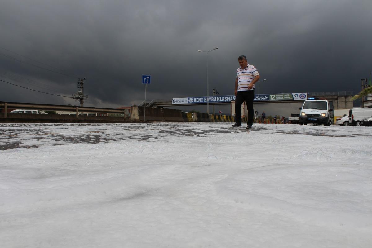 Kocaeli'nde yola d&ouml;k&uuml;len sabun yağmur sonrası etrafı beyaza b&uuml;r&uuml;d&uuml;