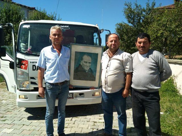 İşçiler çöpte buldukları Atatürk portresini temizleyip kadın muhtara hediye etti