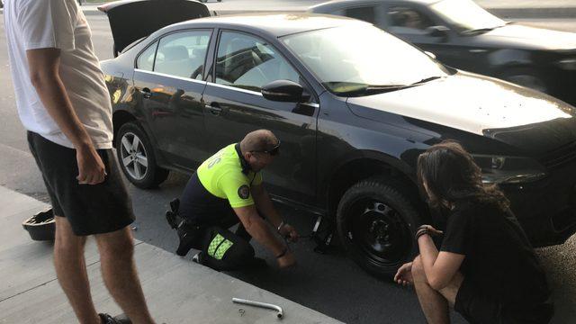 Trafik polisi gençlerin yardımına koştu, araçlarının lastiğini değiştirdi