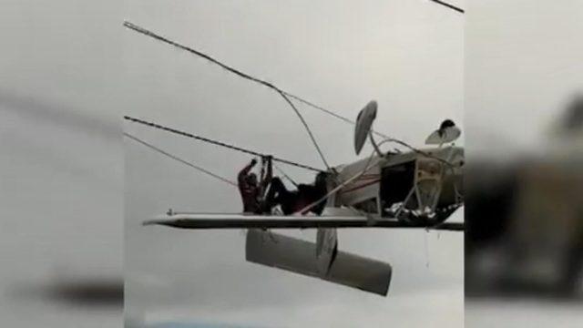 Uçak elektrik tellerinde asılı kaldı, pilot kanada oturup kurtarılmayı bekledi