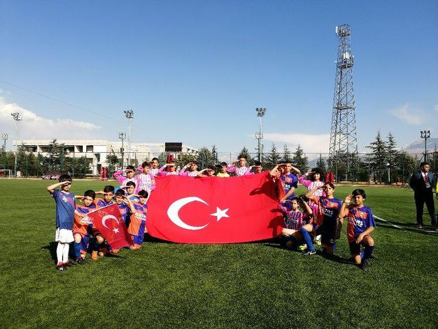 Yeşil sahada, miniklerden Türk Bayraklı asker selamı