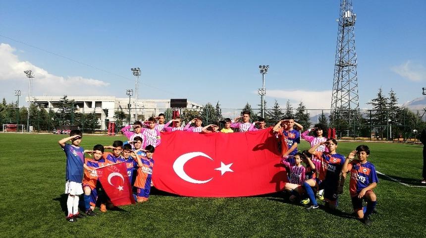 Yeşil sahada, miniklerden T&uuml;rk Bayraklı asker selamı