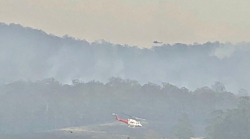 Avustralya&rsquo;da devam eden yangınlara m&uuml;dahale eden bir helikopter d&uuml;şt&uuml;