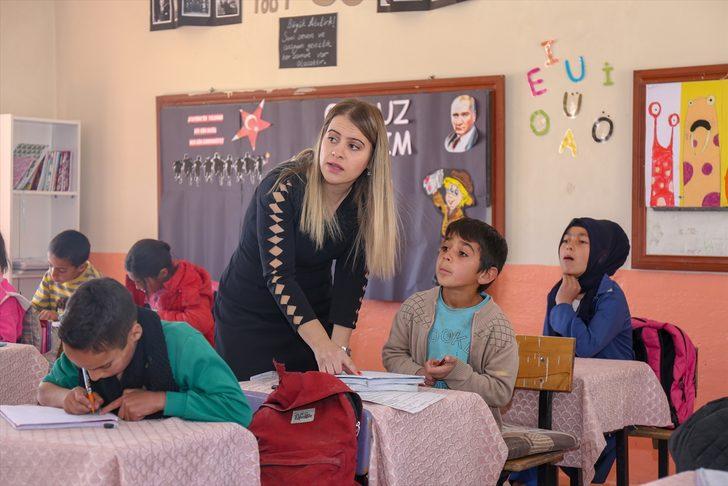 Elif öğretmen, okuma yazma öğrettiği çocuklar ve anneleriyle kitap okuyor G1