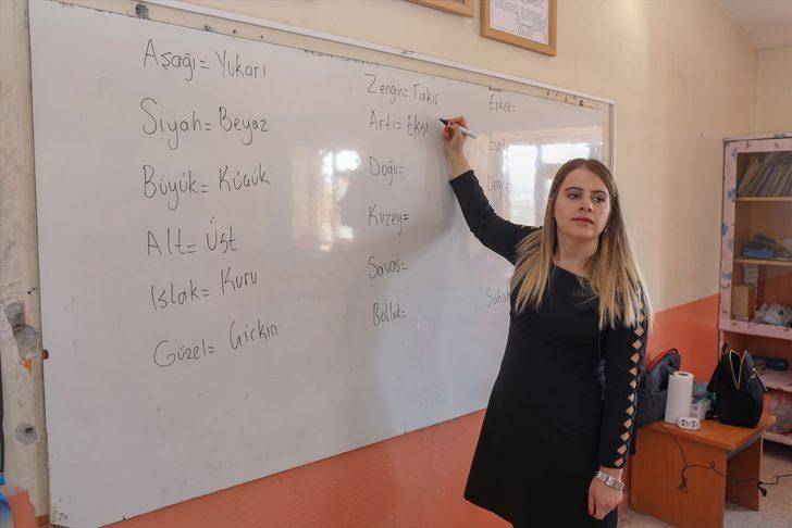 Elif öğretmen, okuma yazma öğrettiği çocuklar ve anneleriyle kitap okuyor G2