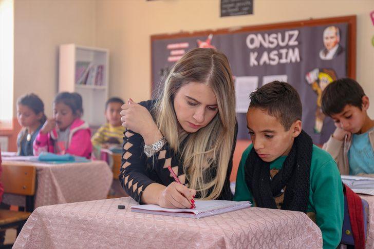 Elif öğretmen, okuma yazma öğrettiği çocuklar ve anneleriyle kitap okuyor G3