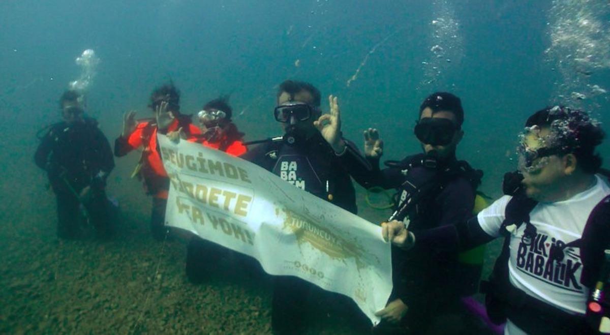 İlgili babalardan su altında " Sevgimde Şiddete Yer Yok" pankartı