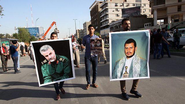 Irak'ta Suudi Arabistan'ın Yemen'deki operasyonlarını protesto eden göstericiler, Kasım Süleymani ve Husi lideri Abdülmelik el Husi'nin portrelerini taşıyor.