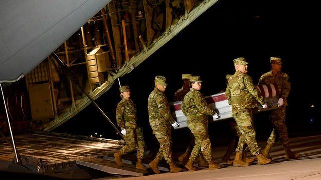 Military personnel carry a transfer case for fallen service member Navy Ensign Joshua Watson. 8 Dec 2019