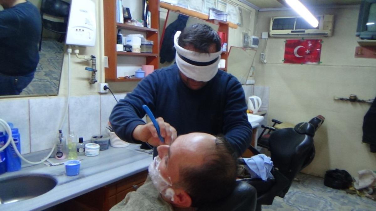 Osmaniye'deki berber, m&uuml;şterilerini g&ouml;z&uuml; kapalı tıraş ediyor