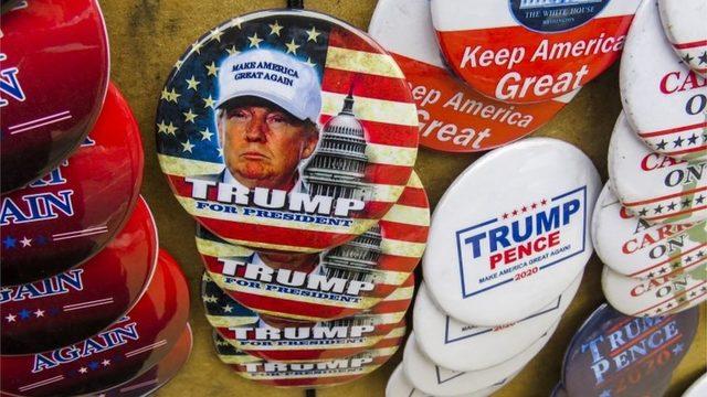 Campaign buttons are displayed for sale before US President Donald J. Trump