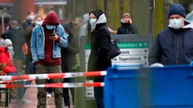 Almanya'da maskeleriyle yürüyen insanlar