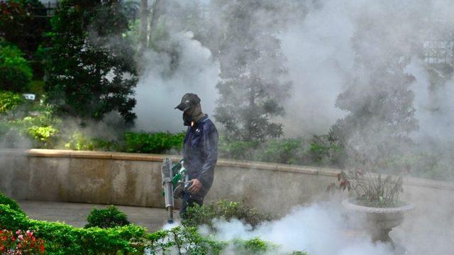 A mask-clad worker disinfects an area to prevent the spread of Covid-19 in Xindian district in New Taipei City, Taiwan