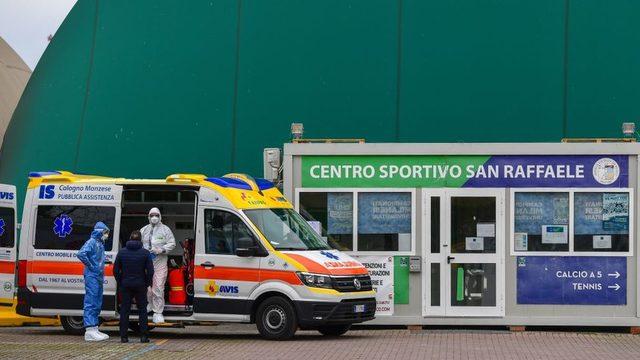 Milano'da yoğun bakım merkezi haline getirilmiş bir spor merkezinin dışında doktorlar ambulans bekliyor
