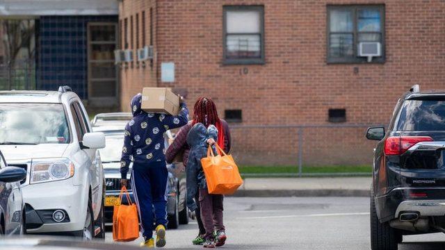 A group of people depart from a church where food and essential supplies are distributed