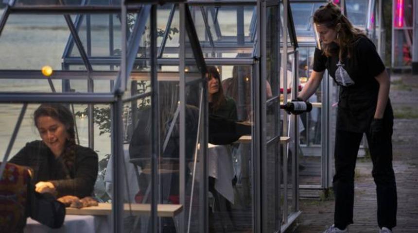 Amsterdam’daki bir restoranda müşteriler özel seralarda yemek yiyor