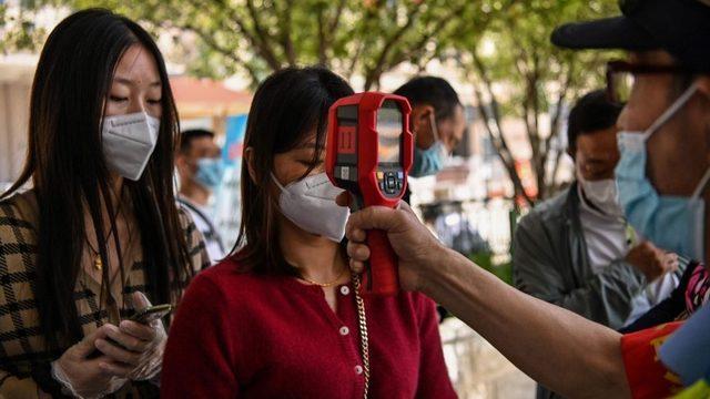 Vuhan'da insanların ateşleri ölçülüyor