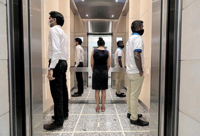 Sri Lanka'daki Dünya Ticaret Merkezi binasında, asansörlerde sosyal mesafe kuralı bu şekilde prova ediliyor.
