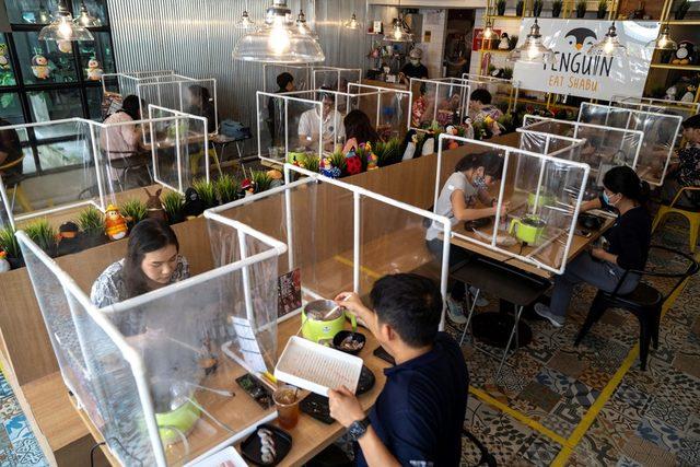 Taylan'ın Bangkok kentindeki bir restoranda sosyal mesafe, şeffaf ayıraçlarla sağlanıyor.
